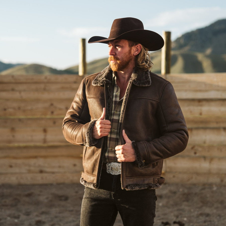 Espresso brown shearling leather bomber jacket with a fur collar and full-length sleeves.